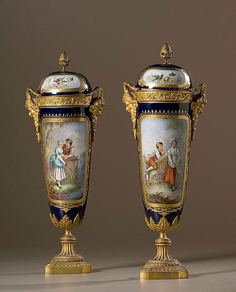 Sevres-Style Porcelain Urns, : Sevres-Style Porcelain Urns, French, late 19th century. A pair, each with a typical "U" shaped body painted with reserves of courting couples in a landscape, each signed A. Daret, with mounted gilt