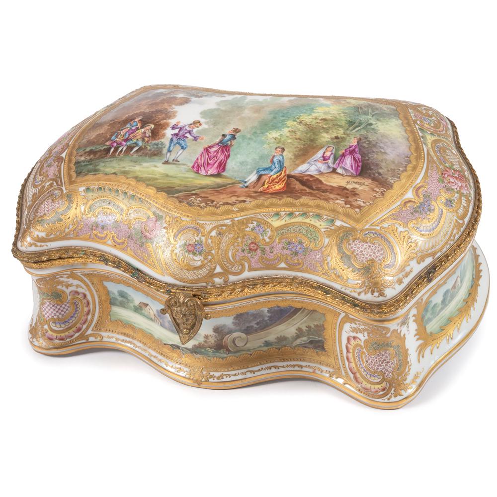 A Chateau de Versailles Porcelain Dresser Box: French, 19th/20th Century having ormolu mounts and gilt decoration and finely painted reserves of courtship and landscape scenes. signed G. Imonez to lid, with Chateau de Versailles mark to underside.