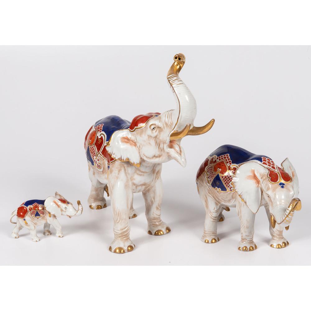 Three Capodimonte Porcelain Elephants: Continental, Early 20th Century with handpainted polychrome decoration and gilt accents. each with underglaze N with crown. Height of largest 13 3/4 x length 16 inches.