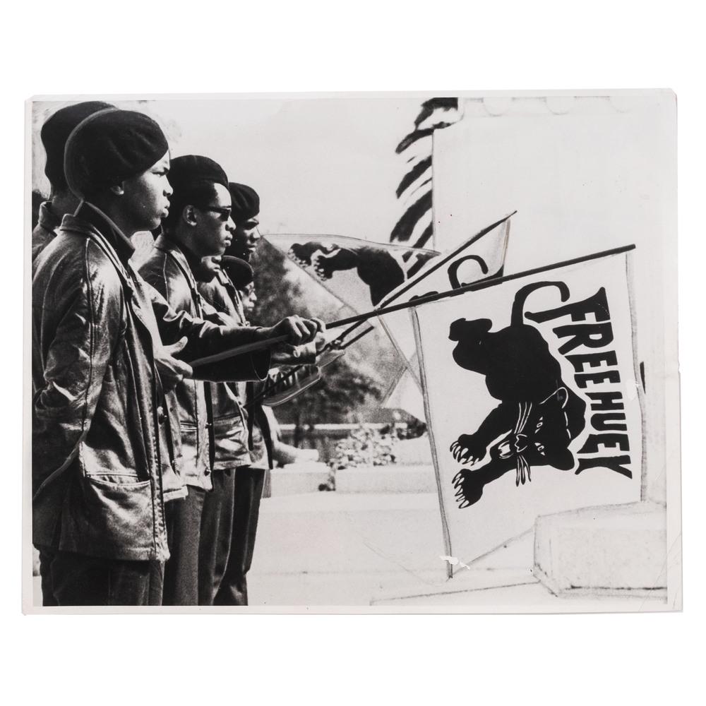 [BLACK PANTHERS]. Press photograph of Black Panther: [BLACK PANTHERS]. Press photograph of Black Panther Party members protesting the trial of their leader, Huey Newton. Oakland, CA, [July 1968]. 10 x 8 in. silver gelatin photograph (diagonal crease thr