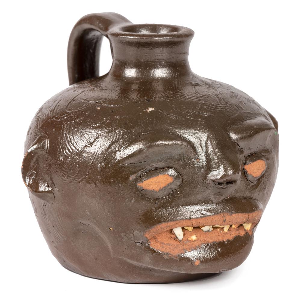 A Guy Daugherty Brown-Glaze Stoneware Face Jug,: A Guy Daugherty Brown-Glaze Stoneware Face Jug, Bethune, South Carolina, Circa 1950 initialed on underside. Height 3 7/8 inches. Property from the Estate of James A. Sanders, Evansville, IndianaHindma