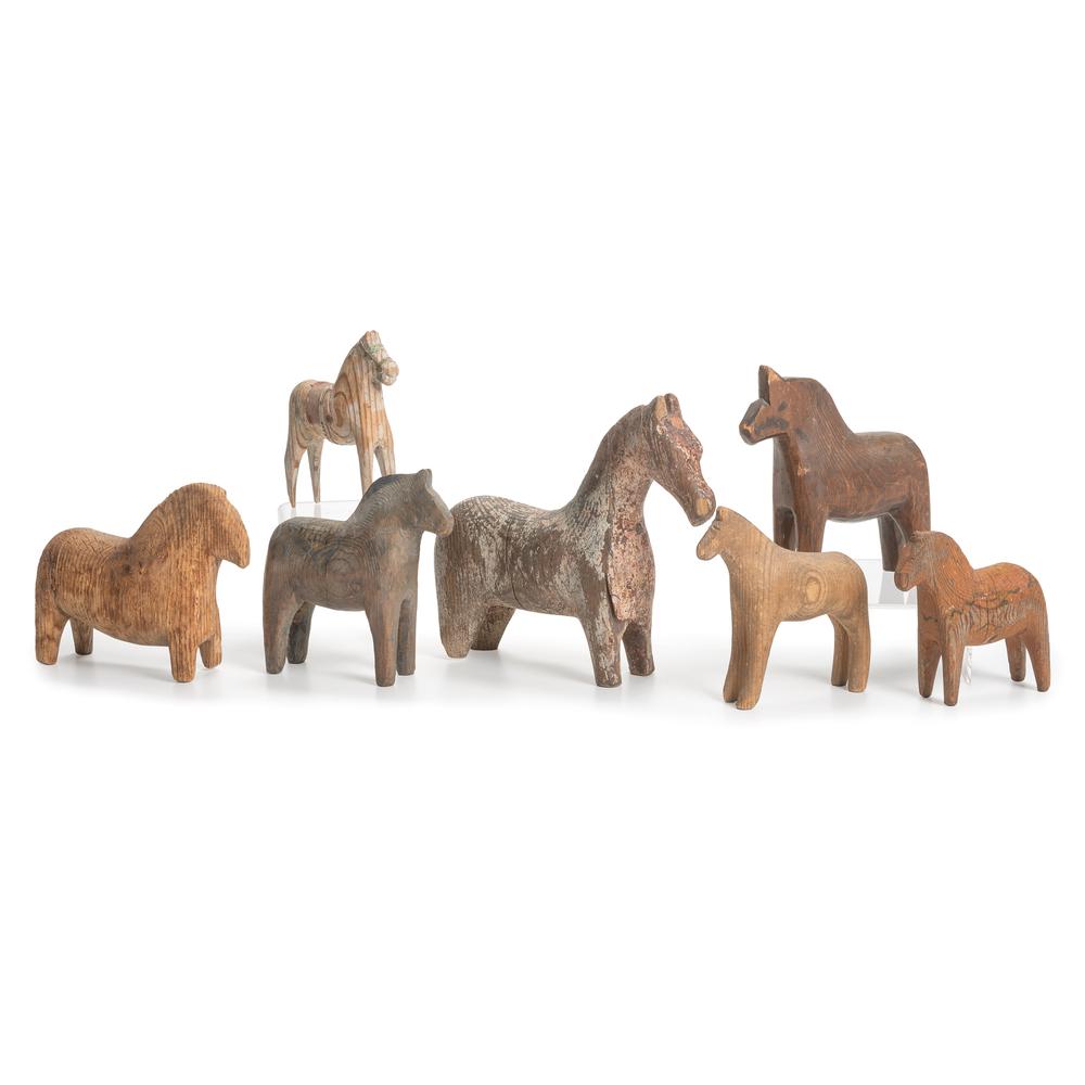 Seven Swedish Dala Horses: Seven Swedish Dala Horses with faint remnants of paint decoration. one with label for Akta / Dalahemslojd / Tillv. G.A. / Olsson / Nusnas, Mora, Sweden. Height of largest 6 1/2 x length 7 1/2 x width 