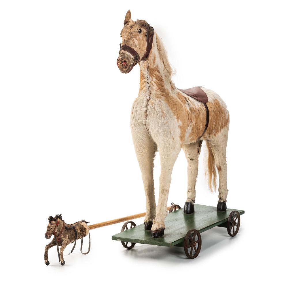A Riding Horse Pull Toy and Hobby Horse: A Riding Horse Pull Toy and Hobby Horse 20th Century pull toy on a painted wooden platform on iron wheels. Height 28 x length 22 1/2 inches. Length of hobby horse 35 1/2 inches. Property of the late K