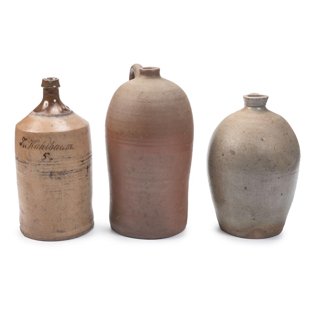 Two Stoneware Jugs and One Bottle: Two Stoneware Jugs and One Bottle 19th Century one jug having an incised four gallon capacity mark to shoulder, and bottle, likely of German origin, marked F. Kahlbaum. / 5. Height of largest 16 1/2