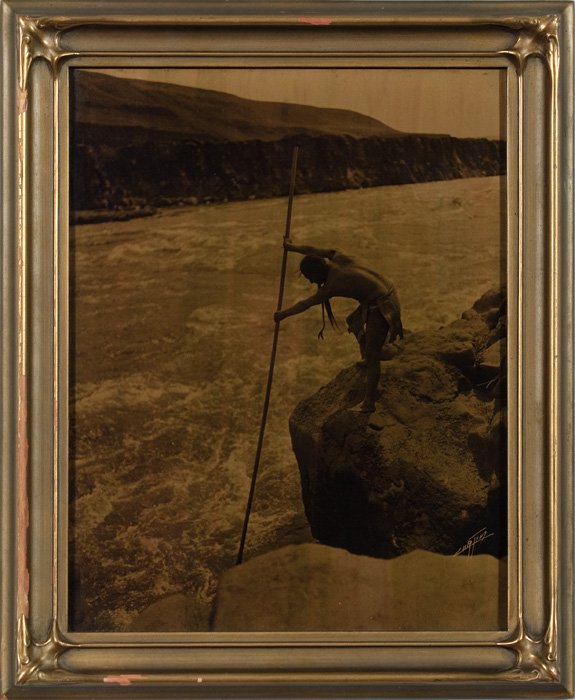 Edward Curtis Orotone The Salmon Fisher : Edward Curtis Orotone The Salmon Fisher, 11 x 14" signed lower right, in original Curtis "bat-wing" style frame, with original Curtis label on verso A Curtis Indian and in manuscript The Salmon Fisher