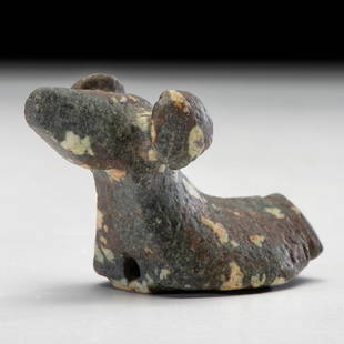 A Salvaged Porphyry Popeye Birdstone, with Red Ocher: Glacial Kame Culture, Late Archaic Period, 3000-500 BCE length 3 in. Crafted of highly contrasting cream and dark gray porphyry; head with upturned nose and large round popeyes; body has a slight