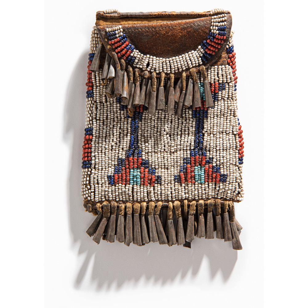 Central Plains Beaded Strike-a-Light Case: sinew-sewn boot leather; decorated using glass beads of red white-heart, light blue, dark blue, and white; tin cone fringe length 5 in. x width 3.5 in. fourth quarter 19th century