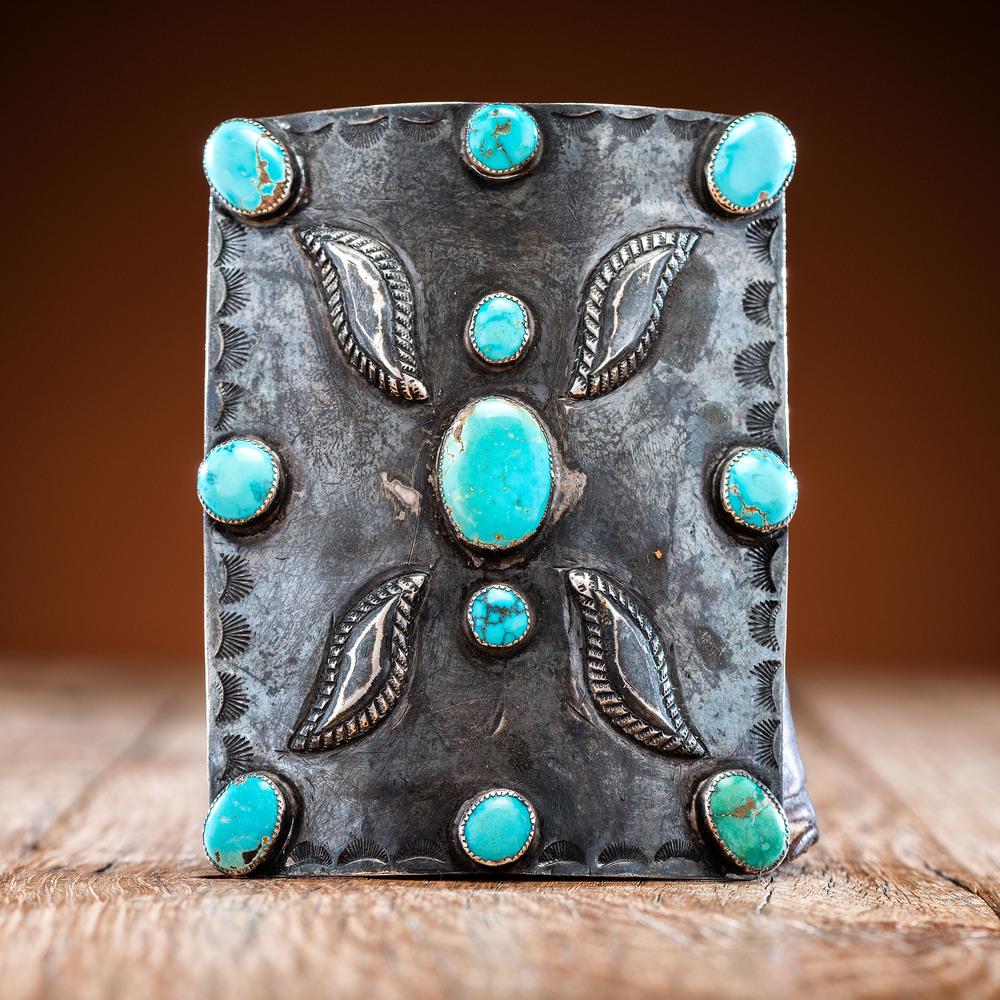 Navajo Silver and Turquoise Ketoh: a rich leather band with a stamped rectangular silver decoration inlaid with eleven turquoise stones length 9.75 in. x width 4 in. second quarter 20th century Provenance: Ex collection of William H. S