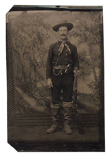 Oversized Tintype of Cowboy with M-1873 Winchester: Oversized Tintype of a Cowboy with his M-1873 Winchester. A studio portrait of a cowboy armed with a Model 1873 Winchester Rifle and a Smith & Wesson Model 1.5 Single Action Revolver, ca 1880-1890, 3.