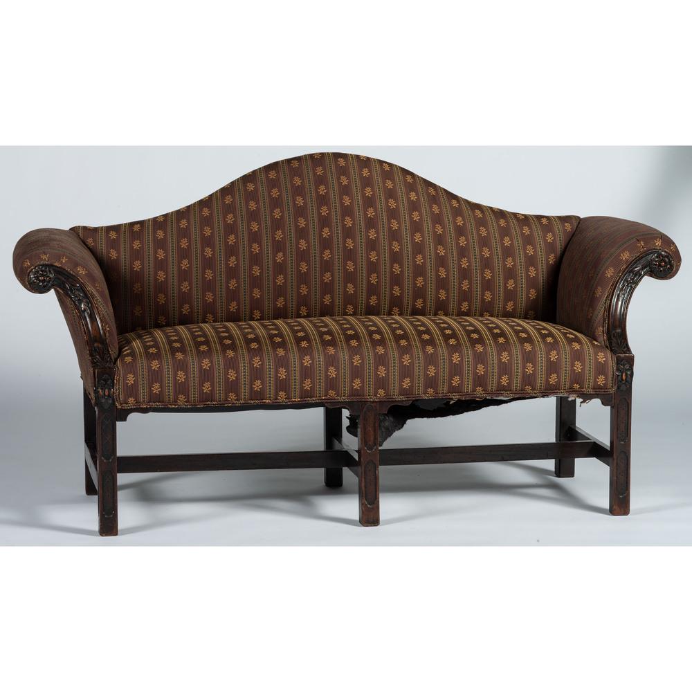 An Irish George III Carved Mahogany Camel-Back Sofa: 18th Century showing rosette, acanthus and diaper pattern decorations. Height 33 1/2 x width 62 1/2 inches.