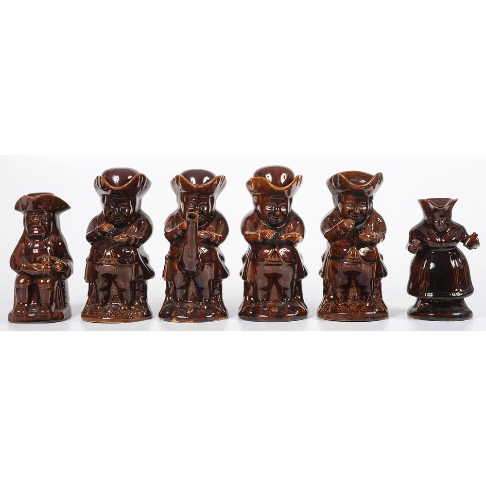 Six Toby Pitchers in Dark Brown Glaze: all full figured with four examples depicting Toby taking snuff, one with woman holding a bottle and one with seated figure holding a glass. four retain their hat shaped lids. each unmarked. Height