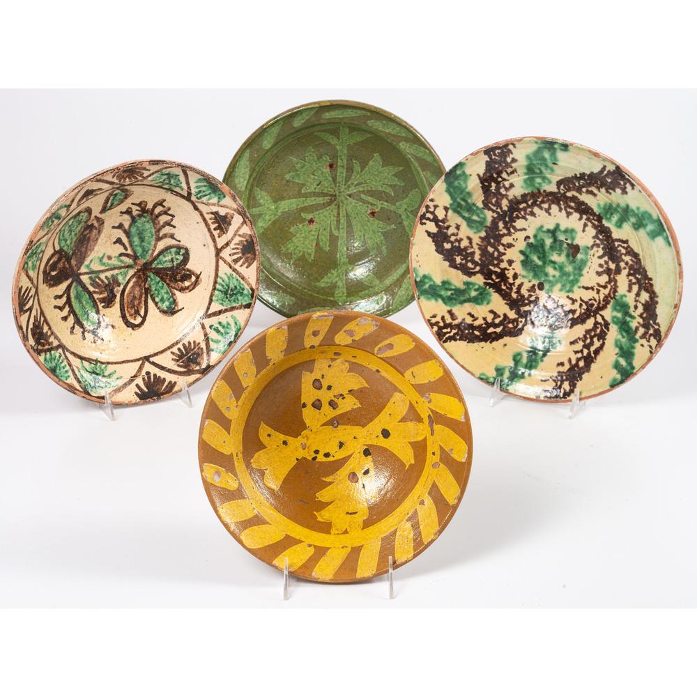 Four Tin Glazed Redware Bowls: 19th/Early 20th Century each with glazed floral and leaf decorations. unmarked. Height of largest 4 x diameter 12 1/2 inches. Provenance: Property from the Estate of James A. Sanders, Evansville, Indi