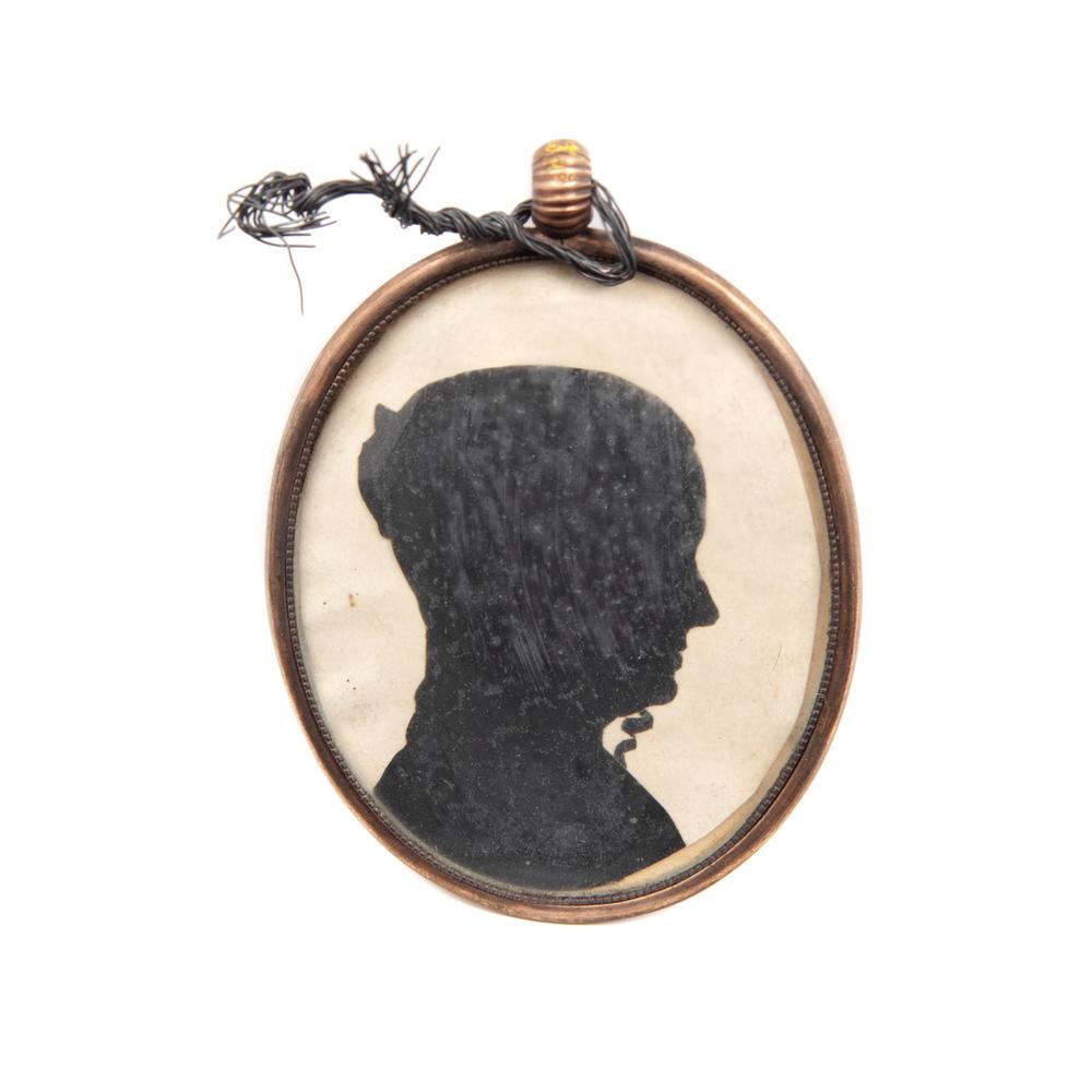A Cut Paper Silhouette Portrait Mourning Locket: 19th Century with lock of hair encased on verso. Image 2 1/4 x 1 5/8 inches. Provenance: Property from the Collection of Jeffrey Zeno, Long Beach, California