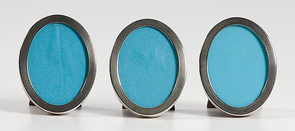 Three Tiffany & Co. Oval Sterling Picture Frames : Three Tiffany & Co. Oval Sterling Picture Frames American, 20th Century, three oval Tiffany & Co. sterling frames with tooled design and mahogany backs, marked Tiffany & Co., Sterling, lg. 4, wd. 3 
