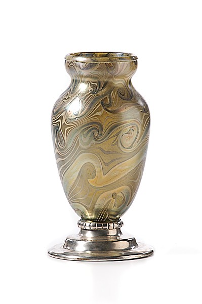 King Tut Art Glass Vase : King Tut Art Glass Vase Early 20th century. A shouldered form vase in the "King Tut" pattern, having green and gold iridescent swirls with lavender highlights, mounted on a flaring silver-plated bas