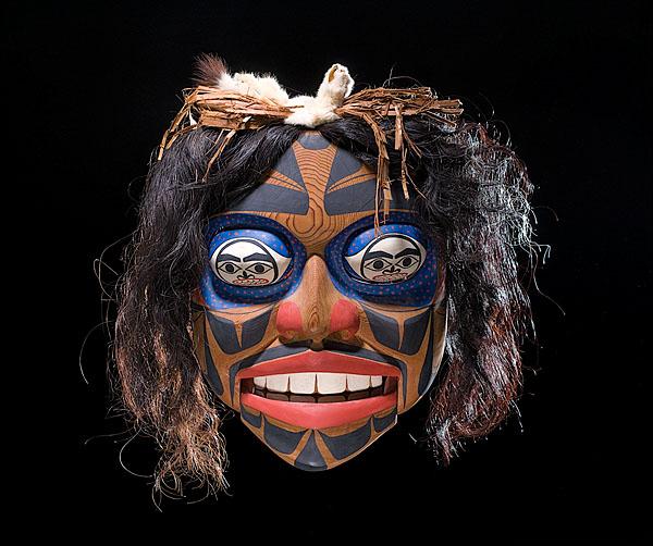 Don Lelooska Kwakiutl Articulated Mask : Don Lelooska Kwakiutl Articulated Mask Carved of wood with rolling eyes and movable jaw; eyes painted with faces and dots signifying night and day; detailed with horsehair, ermine, and cedar bark; s