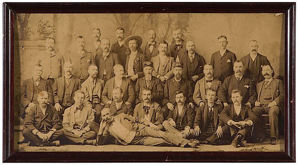 Group Portrait Featuring Captain Jack Crawford : Group Portrait Featuring Captain Jack Crawford Albumen, 10 x 19 in., ca late 19th century. Group of 29 men, all but Jack in suits (most with vests, watch chains, mustaches). In center are two men in