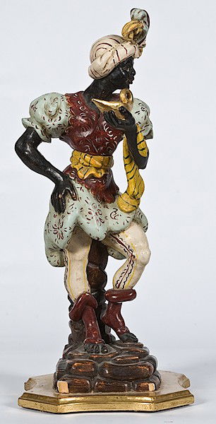 Blackamoor Figure : Blackamoor Figure Continental, a carved wood and polychromed Blackamoor figure wearing a fancy robe, holding a gold genie's lamp, and standing on a rocky pedestal; ht. 23.5 in.