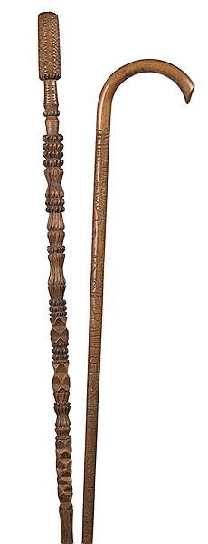 Carved Folk Art Cane and Walking Stick : Carved Folk Art Cane and Walking Stick American, early 20th century. A chip carved stick with "corn cob" style handle; lg. 46 in. Also, a carved cane with curved handle and multiple motifs including