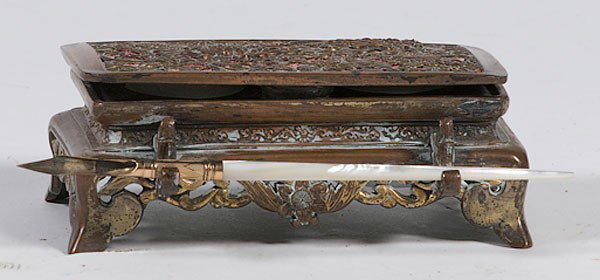 Bronze Standish : Bronze Standish 20th century, a bronze inkwell with openwork design on hinge cover, two opaque glass inserts and a front quill holder; ht. 2, lg. 5, dp. 3 in.