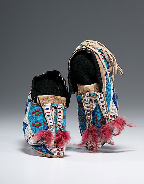 Sioux Beaded Hide Moccasins : Sioux Beaded Hide Moccasins Thread and sinew-sewn; using glass beads of light and dark blue, red, pea green, and white; bifurcated tongues finished with tin cones and red dyed feathers; dusters on h
