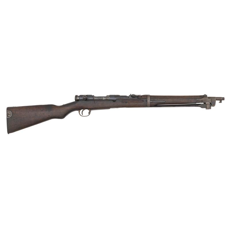 ** Arisaka Type 44 Carbine: 6.5x50mmSR Arisaka. 19" barrel length. SN: 22258. Bolt action rifle with adjustable rear leaf sight and folding bayonet. Item features blued metal finish with two piece wood stock. "{Koshikawa Arsenal