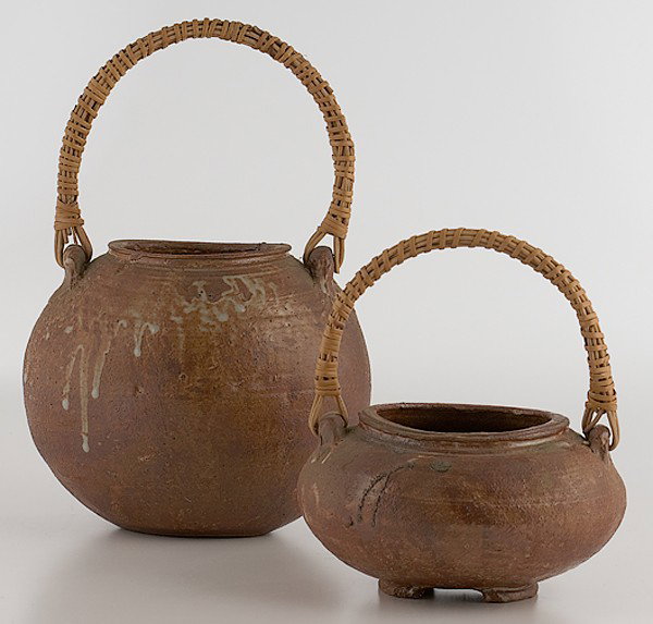 Potters' Market: Nana Two Handled Vessels : Nana Two Handled Vessels Two earthenware vessels in brown glaze with white slip and reed handle; signed Nana?; tallest: ht. 12, wd. 8 in. From the Collection of Dorothy Miner.