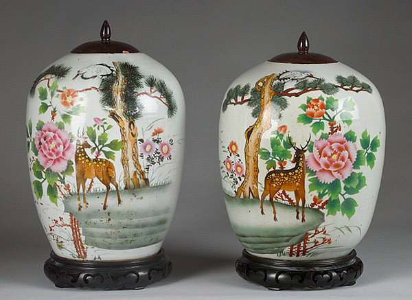 CHINESE JARS ON STANDS : PR. CHINESE JARS ON STANDS Chinese, late 19th - early 20th century. A pair of Chinese ginger jars decorated with enameled forest flowers and animals with turned wooden lacquered lids and carved teak