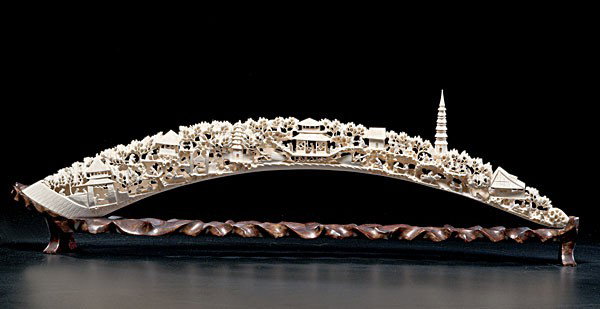 Chinese Carved Ivory Tusk : Chinese Carved Ivory Tusk Chinese, carved ivory tusk depicting a village with figures, buildings, and pagodas, on 20th century wooden stand; lg. 25 in.