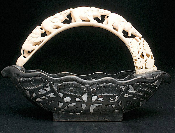Carved Wooden Basket with Ivory Tusk Handle : Carved Wooden Basket with Ivory Tusk Handle Probably African, a carved and pierced wooden basket with carved ivory tusk handle depicting a lion hunting elephants; lg. 18.5, ht. 12 in.