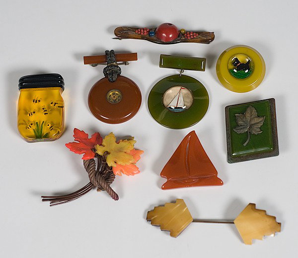 Group of Bakelite Pins, Plus : Group of Bakelite Pins, Plus 20th century, a group of five Bakelite pins including two with sailing ships, one with a compass, one with a Scottie dog and a metal and Bakelite pin with central metal 