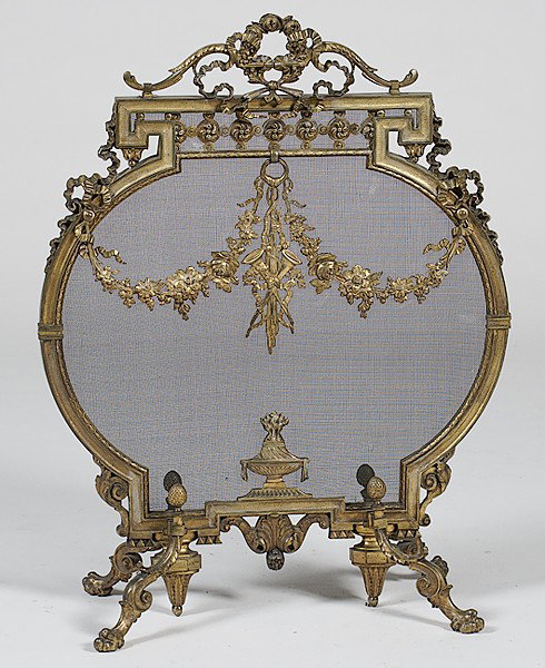 Louis XVI-style Fire Screen : Louis XVI-style Fire Screen French, ca 1840-1860. A Louis XVI-style gilt metal fire screen, the crest rail with wreath and bow motif, above the body with case foliate swags and central musical troph