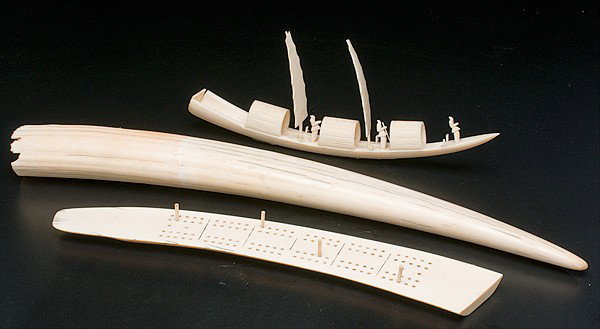 Carved Ivory Items : Carved Ivory Items an assembled group of three ivory items including an undecorated tusk, a carved ship, and a cribbage board; tusk lg. 23 in.