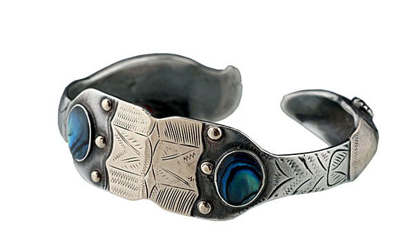 Larry Taranoff Alaskan Silver Bracelet : Larry Taranoff Alaskan Silver Bracelet with gold overlay accenting bird's heads and center motif; eyes feature red stones, possibly garnet, and band features watery blue abalone. Signed on inside La