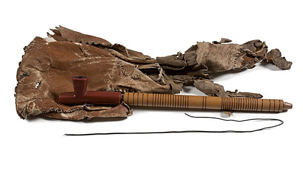 Medicine Crow 's Catlinite Pipe Bowl, Stem, and Ba: Medicine Crow 's Catlinite Pipe Bowl, Stem, and Bag lot of 3. Includes catlinite bowl of T-form accompanied with wooden stem decorated with 43 concentrically red-tinted carved rings, total length 17