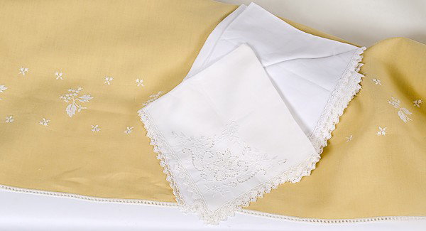 Linens for the Dinner Table : Linens for the Dinner Table Ca 1940s, a set of twelve damask dinner napkins with lace borders and a yellow linen table cloth with white embroidered flowers and an open work lace edge; tablecloth 105