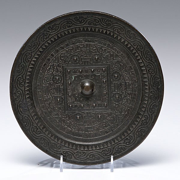 Chinese Bronze TLV Mirror : Chinese Bronze TLV Mirror Chinese, a recast bronze mirror in the Han Dynasty style having a pierced hemispherical knob enclosed by four barbed ruyi heads and a grooved square issuing four T motifs, 