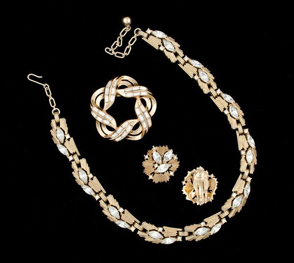 Trifari Costume Jewelry : A grouping of Trifari jewelry that includes a brooch, a pair of ear clips and a necklace. A Trifari brooch with baguette cut rhinestones and a star pattern, a pair of Trifari ear clips with rhinestone