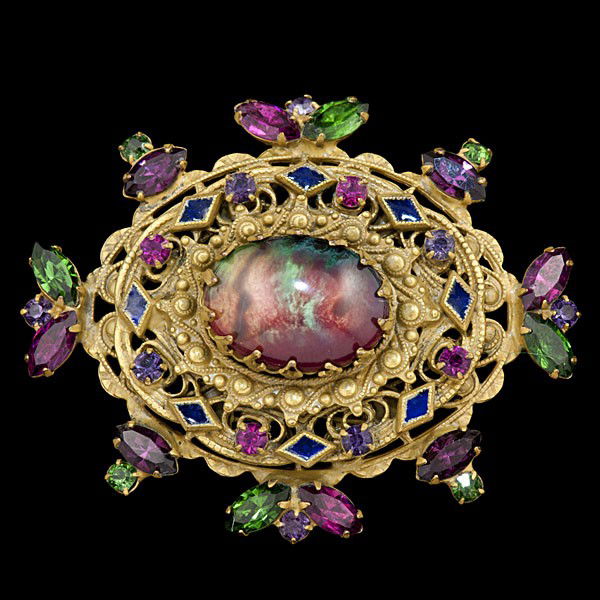 Weiss Multi Colored Brooch : Weiss Multi Colored Brooch A Weiss brooch, a mix of multicolored rhinestones set in an antique style oval gold-toned setting, large multicolored opaque bead in the center. Stamped: Weiss.