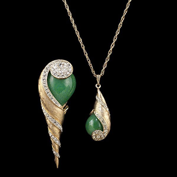 Kramer Seashell Suite : Kramer Seashell Suite Pendant and brooch suite set; necklace has a brushed gold tone shell shape, accented with rhinestones and a green cabochon; brooch is larger with the same motif.