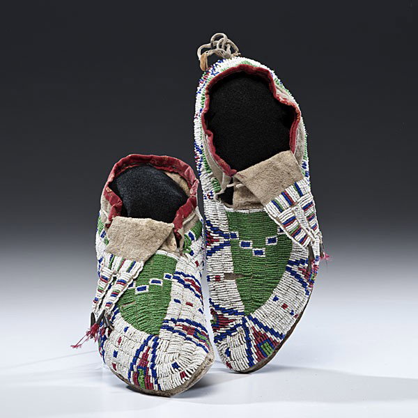 Sioux Beaded Hide Moccasins : Sioux Beaded Hide Moccasins Sinew-sewn and beaded using colors of pea green, red white-heart, dark blue, and white; bifurcated tongues are finished with red-dyed feathers and cuffs finished with pat