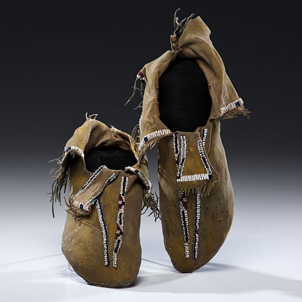 Comanche Beaded Hide Moccasins : Comanche Beaded Hide Moccasins Thread and sinew-sewn using bead colors of cobalt, white, light blue, and rose; hints of yellow and blue pigment on hide; short beaded hide flap sewn along heel seam, 