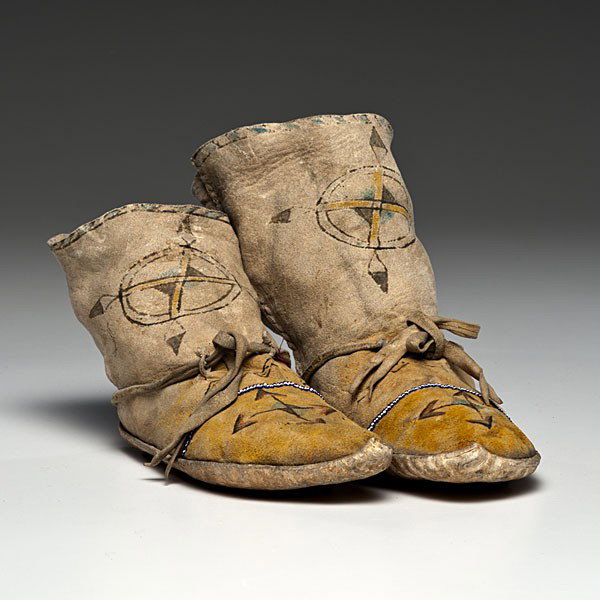 Apache Gan Dancer Hide Moccasins : Apache Gan Dancer Hide Moccasins Sinew-sewn and painted using yellow, red, and blue pigments; barbershop pole design decorates upper edge of moccasin, while feathers and arrows point to the four dir