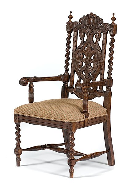 Tudor-style Carved Armchair : Early 20th century. A Tudor-style oak armchair with extensively carved back, turned finials, stretchers and arm supports, twist stiles and front legs; rear legs are incurving; ht. 47.5, seat ht. 19 in