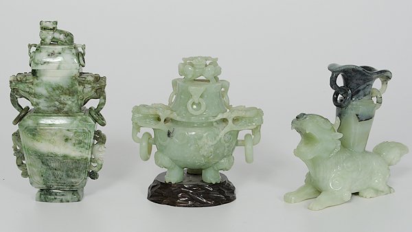 Chinese Jade Vessels : 20th century. An assembled group of three jade vessels including: one tripod lidded vessel with a mythological beast finial and three handles with loose rings; one lidded baluster form vessel with arc