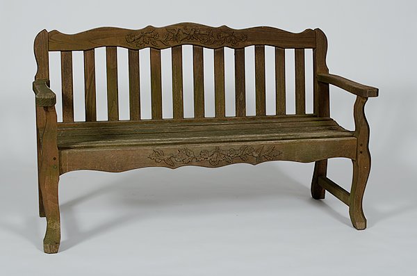 Garden Bench : Garden Bench 20th century, a garden bench in oak having carved crest and skirt and vertical slat back; lg. 55 in.