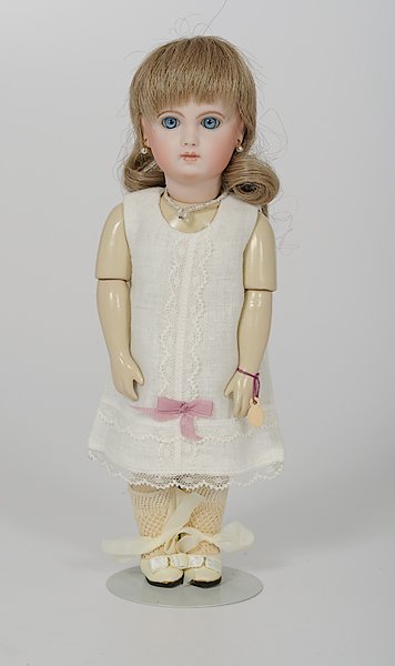 French Reproduction Jumeau Doll : French Reproduction Jumeau Doll French, a reproduction bisque head doll having blue paper weight eyes, closed mouth, pierced ears, blonde wig, composition jointed french body, dress in white combina