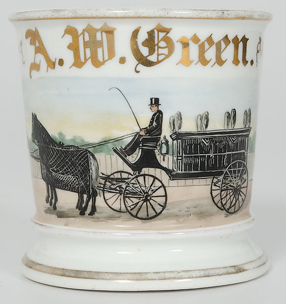 Undertaker's Occupational Shaving Mug : Undertaker's Occupational Shaving Mug Porcelain with polychrome painted scene of an undertaker dressed in black, driving a coffin-shaped hearse with horses draped in black. Gilt name A.W. Green, wit
