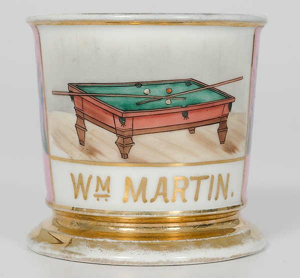 Billiard Player's Occupational Shaving Mug : Billiard Player's Occupational Shaving Mug Porcelain with polychrome painted scene of a billiards table with balls and crossed cues. With pink wrap, floral pattern, and gilt name W.M. Martin. Bottom