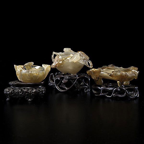 Agate Water Coupes : Agate Water Coupes Chinese, 19th century. A group of three agate water coupes each with ornately carved wooden stands, one having a lotus flower motif, the other two having leaf motifs in reli
